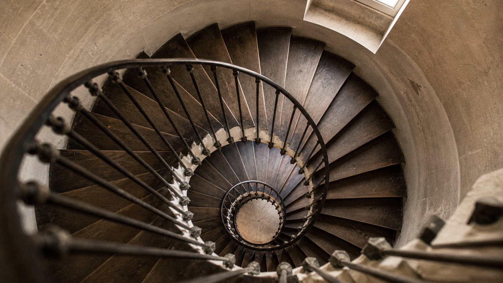 Escalier helicoidal sculptural en acier et bois s'enroulant dans un sejour a l'espace compact